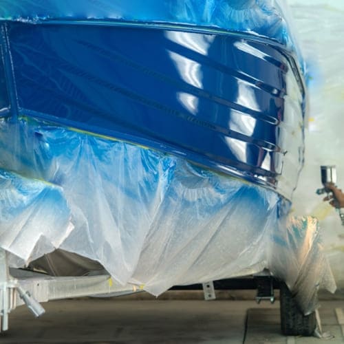 painting a boat with sprayer